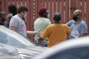 Một quan chức phát giấy đăng kí thất nghiệp tại Mỹ. Ảnh: AP