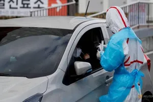 Một nhân viên y tế đang lấy mẫu của một vị khách tại Trung tâm y tế đại học Yeungnam, Daegu, Hàn Quốc. Ảnh: REUTERS