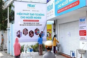 Hình ảnh người dân đứng xếp hàng chờ lấy gạo từ máy "ATM gạo" được đăng trên hãng tin Reuters. Ảnh: REUTERS