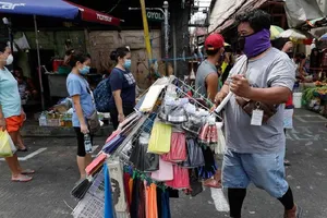 Người dân thủ đô Manila (Philippines) đeo khẩu trang và giữ khoảng cách tại một khu chợ ở thành phố hôm 23-4. Ảnh: AP