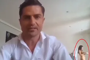 Tình nhân của ông M. xuất hiện trên khung hình khi ông trả lời phỏng vấn trực tuyến. Ảnh: RT/YOUTUBE