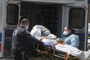 Nhân viên y tế di chuyển bệnh nhân COVID-19 ở bang New York, Mỹ ngày 23-4. Ảnh: AFP