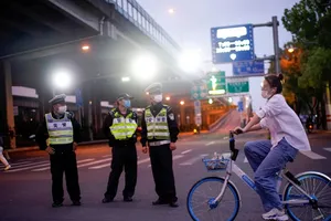 Cảnh sát đeo khẩu trang làm nhiệm vụ trên đường phố Thượng Hải, Trung Quốc hồi tháng 2-2020. Ảnh: REUTERS