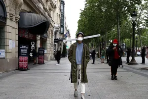 Giãn cách xã hội bằng "chiếc mũ 1 mét". Ảnh: EPA