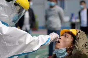 Nhân viên y tế xét nghiệm cư dân TP Vũ Hán, Trung Quốc ngày 15-5. Ảnh: REUTERS