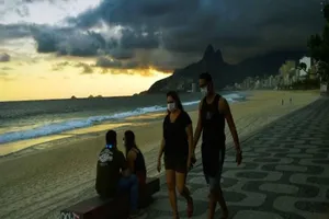 Người dân đeo khẩu trang đi dạo trên bãi biển ở Rio de Janeiro. Ảnh: AFP