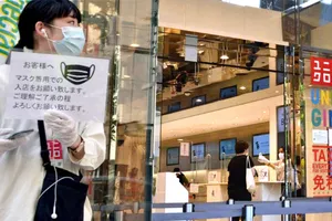 Khách hàng đeo khẩu trang mua sắm ở một cửa hàng Uniqlo ở thủ đô Tokyo, Nhật Bản hồi tháng 3-2020. Ảnh: REUTERS