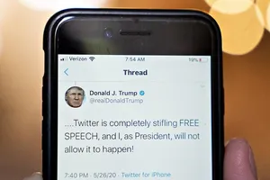 Một người dùng Twitter đang xem đọc đoạn tweet của Tổng thống Mỹ Donald Trump chỉ trích Twitter dán nhãn "thông tin sai sự thật" lên bài đăng của mình. Ảnh: BLOOMBERG