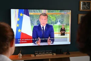 Một gia đình Pháp nghe bài phát biểu của Tổng thống Emmanuel Macron trên kênh truyền hình TFI. Ảnh: AFP