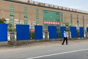 Một nhân viên an ninh kiểm tra khu vực chợ đầu mối Tân Phát Địa ở thủ đô Bắc Kinh (Trung Quốc). Ảnh: REUTERS