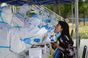 Nhân viên y tế lấy mẫu xét nghiệm COVID-19 cho một người dân Bắc Kinh. Ảnh: REUTERS