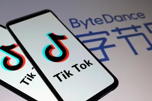 Logo Tik Tok được nhìn thấy trên điện thoại thông minh ở phía trước logo ByteDance. Ảnh: REUTERS