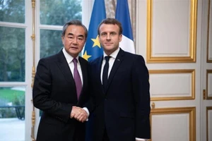 Bộ trưởng Ngoại giao Trung Quốc Vương Nghị (trái) và Tổng thống Pháp Emmanuel Macron. Ảnh: TÂN HOA XÃ