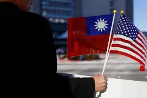 Một người đàn ông cầm cờ Mỹ và Đài Loan.