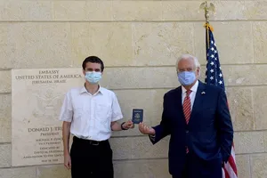 Đại sứ Mỹ tại Israel David Friedman (phải) trao hộ chiếu cho anh Menachem Zivotofsky (trái) hôm 30-10 tại Đại sứ quán Mỹ tại Jerusalem. Ảnh: REUTERS