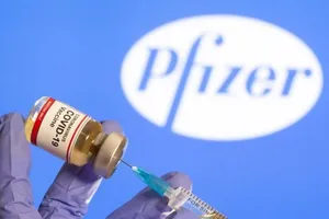 Một nhân viên y tế đang lấy mẫu vaccine ngừa COVID-19 do Pfizer sản xuất. 