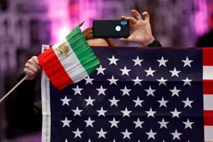 Một người dân Mỹ cầm quốc kỳ Iran và Mỹ tại Los Angeles, California, ngày 11-1.