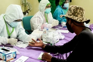 Nhân viên y tế lấy mẫu xét nghiệm COVID-19 tại thành phố Tangerang, Indonesia. Ảnh: THX/TTXVN