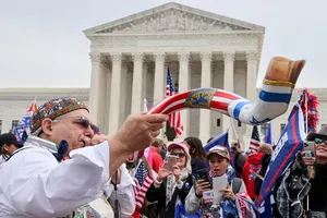 Một người ủng hộ ông Donald Trump thổi kèn shofar truyền thống của người Do Thái trước Tòa án Tối cao Mỹ. Ảnh: REUTERS