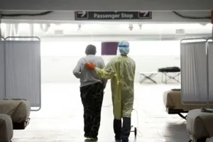 Một y tá giúp một bệnh nhân nhiễm COVID-19 di chuyển tại một bãi đậu xe được biến thành cơ sở chăm sóc đặc biệt ở Reno, Nevada.