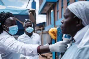 Nhân viên y tế đo nhiệt độ cơ thể của một phụ nữ tại khu ổ chuột Kibera ở Nairobi, vào ngày 18-3.