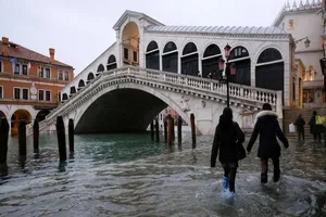 Người dân đi bộ qua cầu Rialto ở Venice trong làn nước lũ.
