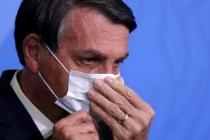 Tổng thống Brazil Jair Bolsonaro điều chỉnh khẩu trang của mình trong buổi lễ tại Cung điện Planalto, Brazil, ngày 19-8-2020.