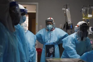 Nhân viên y tế vây quanh một bệnh nhân tử vong do COVID-19 tại Trung tâm Y tế United Memorial ở Houston, Texas, ngày 12-12-2020.