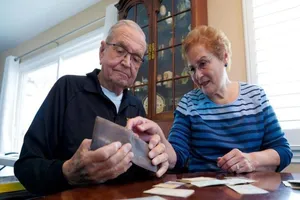 Vợ chồng ông Grisham xem lại giấy tờ trong ví. Ảnh: AP