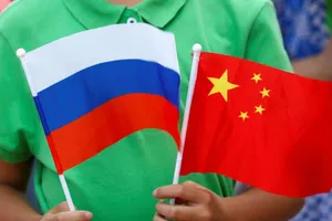 Một đứa trẻ cầm quốc kỳ của Nga và Trung Quốc tại lễ đón Tổng thống Nga Vladimir Putin đến thăm Bắc Kinh, ngày 25-6-2016.