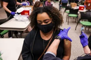 Nhân viên y tế đang chuẩn bị tiêm vaccine cho một người phụ nữ.