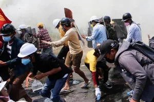 Người dân dùng khiên chắn chống lại hơi cay và vòi rồng do cảnh sát sử dụng trong cuộc biểu tình ở Naypyitaw, Myanmar, ngày 8-3.