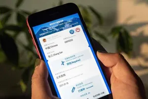 Một phụ nữ cầm điện thoại hiển thị bản mô phỏng ứng dụng "hộ chiếu vaccine" COVID-19 mới của Trung Quốc vào ngày 9-3.