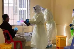 Các nhân viên y tế đang lấy mẫu xét nghiệm COVID-19 của một người đàn ông ở Campuchia.