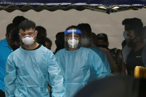 Các nhân viên tuyến đầu tại Singapore mặc đồ bảo hộ đưa một nhóm lao động nhập cư đi cách ly tập trung. Ảnh: REUTERS