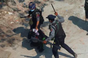 Lực lượng cảnh sát chống bạo động bằt giữ một người biểu tình khi họ giải tán đám đông biểu tình ở thị trấn Tharkata, ngoại ô Yangon, Myanmar, ngày 6-3. 