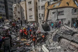 Nhân viên cứu hộ đang tìm cách đưa những thi thể nằm trong đống đổ nát do cuộc không kích của Israel.