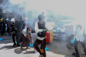 Người biểu tình đeo mặt nạ và kính bảo hộ đối đầu với lực lượng quân đội Myanmar. 