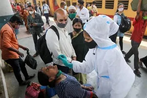 Một nhân viên y tế đang lấy mẫu xét nghiệm từ một phụ nữ tại sân ga ở Mumbai, Ấn Độ, ngày 17-3.