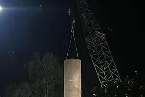 Ống thép được cẩu để lồng vào ôm cọc bê tông, sau đó làm sạch đất để kéo cọc bê tông lên.Ảnh: BÌNH MINH 