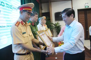 Chủ tịch UBND TP.HCM Nguyễn Thành Phong tặng bằng khen cho các tập thể, cá nhân có thành tích xuất sắc. Ảnh: LÊ THOA