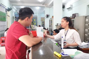 Công chức tư pháp - hộ tịch UBND phường 3, quận Gò Vấp hướng dẫn thủ tục khai sinh và nhập hộ khẩu. Ảnh: TRÚC PHƯƠNG