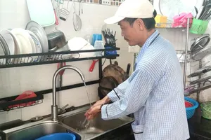 Ông Lại Văn Rao đang chờ kết quả kiểm định đồng hồ nước. Ảnh: NGUYỄN HIỀN