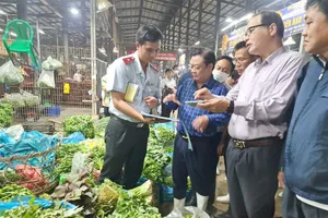 Bộ trưởng Bộ NN&PTNT khảo sát thực tế tại chợ Bình Điền rạng sáng 17-10. Ảnh: NGUYỄN CHÂU