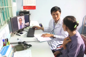 Bác sĩ Trạm y tế xã Tân Nhựt (huyện Bình Chánh, TP.HCM) khám cho bệnh nhân bằng phần mềm hội chẩn từ xa với bệnh viện tuyến trên. Ảnh: NVCC