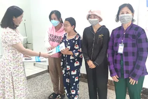 Đại diện cơ quan BHXH TP.HCM tặng quà tết cho bệnh nhân nghèo ở BV Nhi đồng TP.HCM. Ảnh: NGUYỄN HIỀN