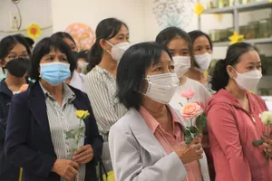 Bà Tăng Thị An Nhi cầm đóa hoa hồng để tri ân người em đã hiến xác cho khoa học. Ảnh: THẢO PHƯƠNG