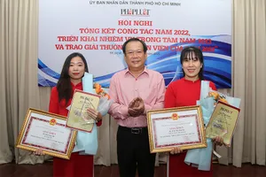 Ông Mai Ngọc Phước, Tổng biên tập báo Pháp Luật TP.HCM, trao giải thưởng cho hai nhân viên xuất sắc năm 2022. Ảnh: HOÀNG GIANG