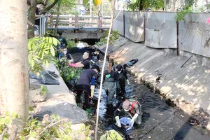 Nhóm Sài Gòn Xanh đang xử lý rác tại con kênh ở hẻm 154 đường Nguyễn Phúc Chu, phường 15, quận Tân Bình. Ảnh: THỦY TÂM