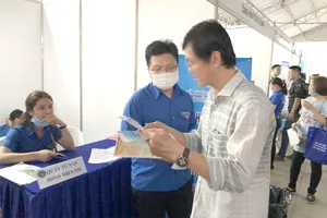 Nhân viên BHXH đang tư vấn cho người dân về các quyền lợi khi tham gia BHXH tự nguyện. Ảnh: VÕ HÀ